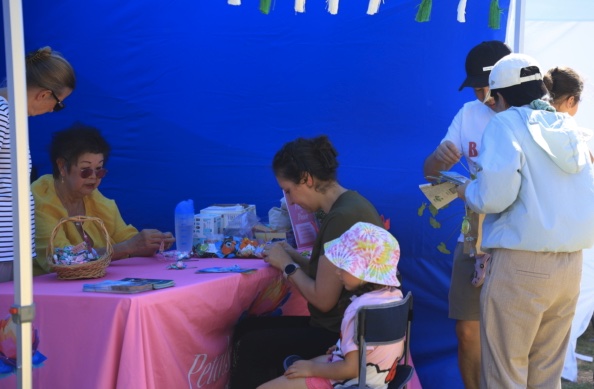 Families making lotus flower keepsakes at the Falun Dafa booth
