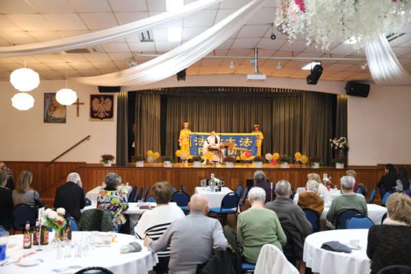 Falun Dafa practitioners on stage holding a banner at the Polish House Syrena