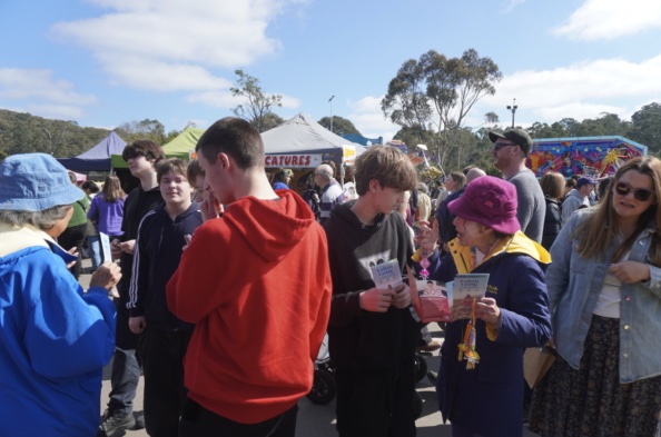 People conversing with a practitioner at the booth