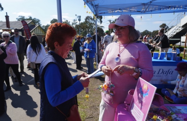 Visitors learning about Falun Dafa at the booth