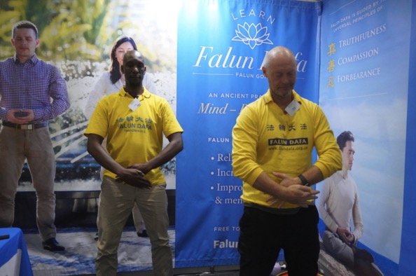 Visitors learning about Falun Dafa at the booth
