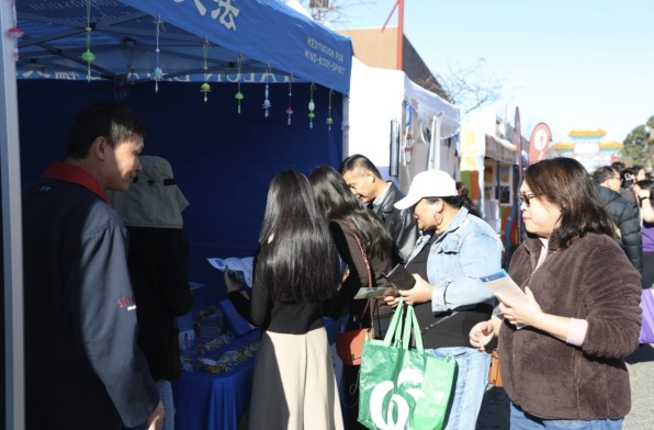 Visitors at the Falun Dafa booth
